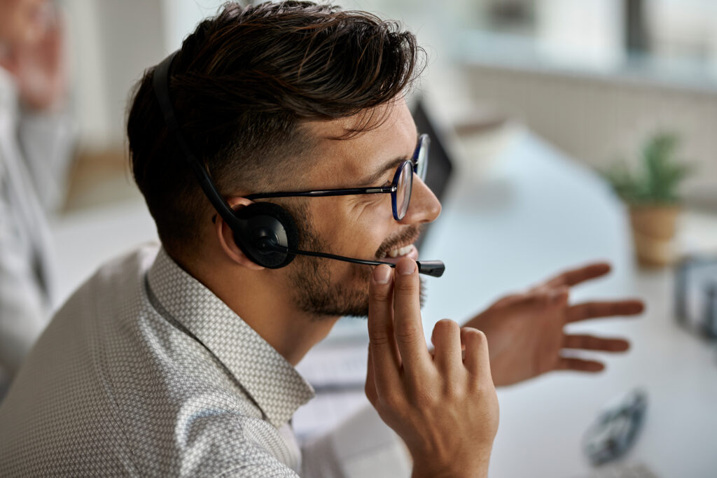 call center agent wearing headset while talking with clients and working in the office.